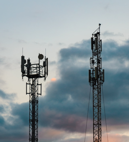 Torres de telecomunicaciones con antenas sobre cielo al atardecer