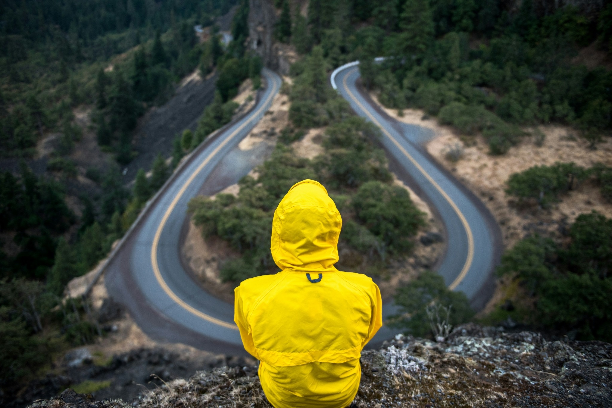 una persona con un chubasquero amarillo en un paisaje de montaña